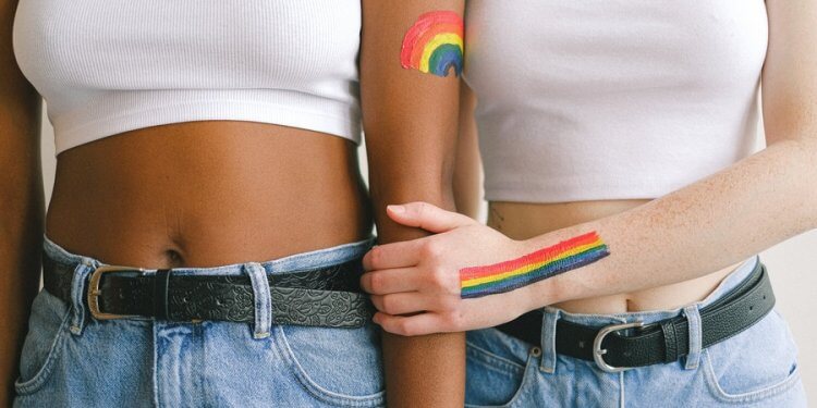 homophobie-wegkuscheln-zwei-junge-frauen-lesbisches-liebespaar-pride-flag